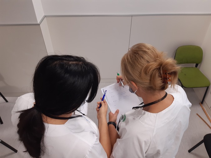 Dos enfermeras se intercambian información entre el turno entrante y saliente
